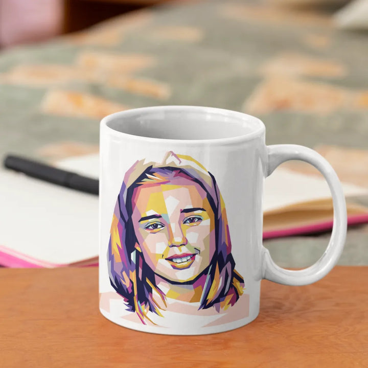 White mug with a colorful portrait of a woman on a wooden surface.