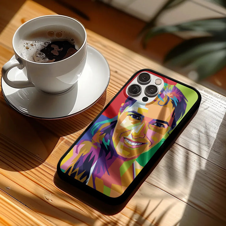 Phone case with colorful design on a wooden table with a cup of coffee