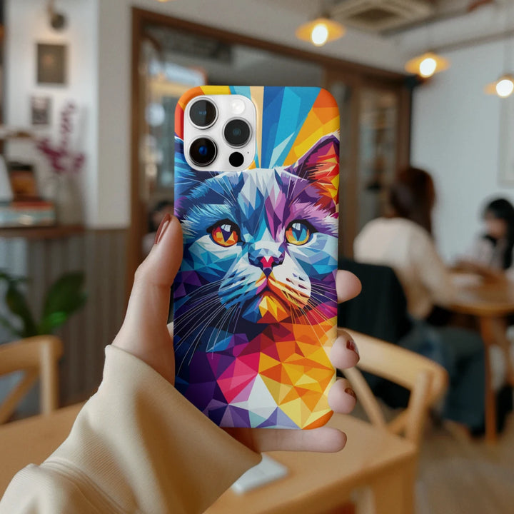 Colorful phone case with a cat design held by a person in a blurred indoor setting