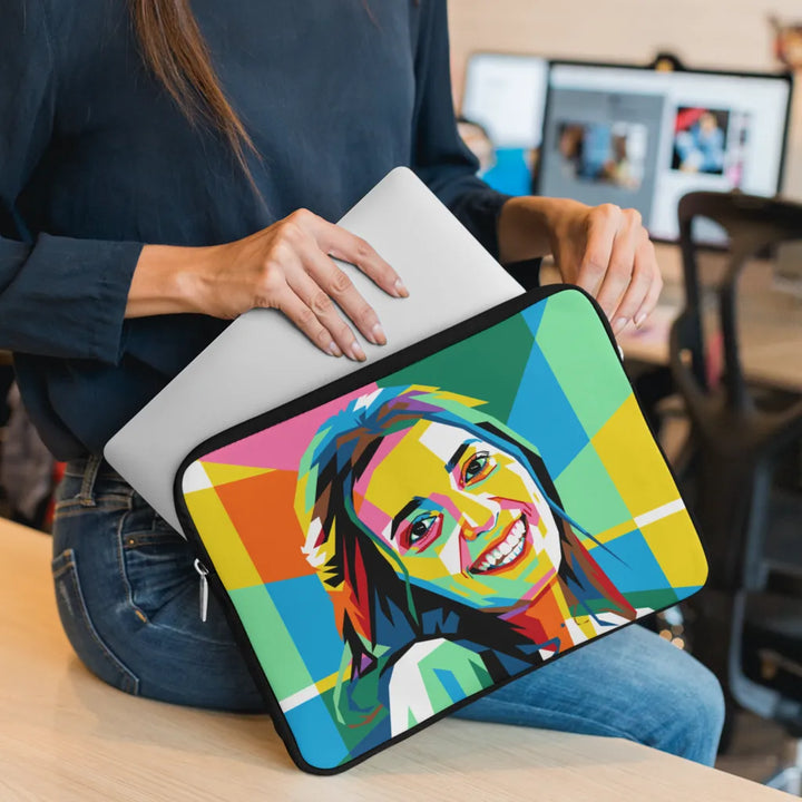 Person holding a colorful laptop sleeve with a graphic design of a smiling person.