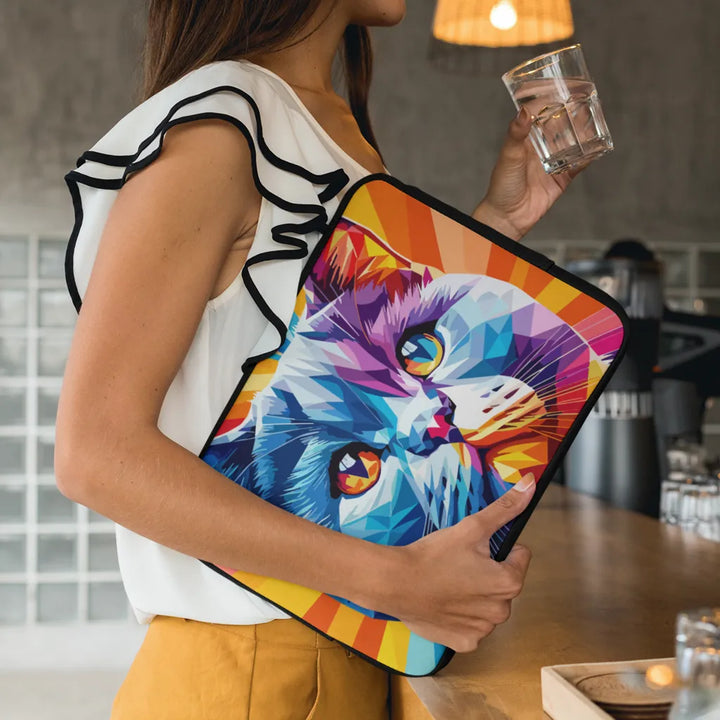 Person holding a colorful laptop sleeve with a cat design in a kitchen setting