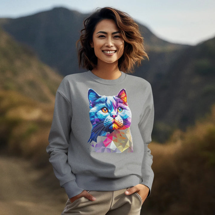 Woman wearing a gray sweatshirt with a colorful cat design in a mountainous landscape
